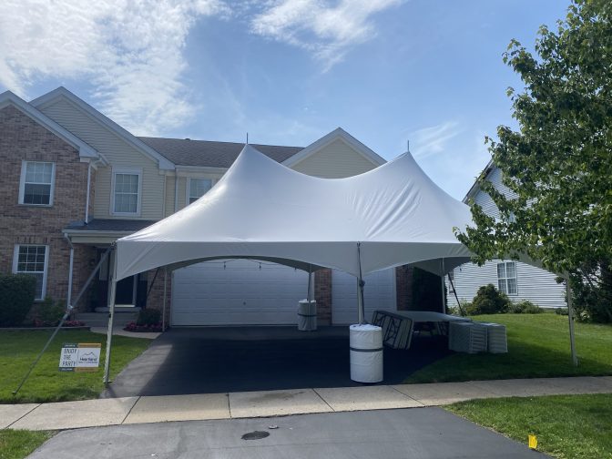 20x30 high peak tent setup on a driveway